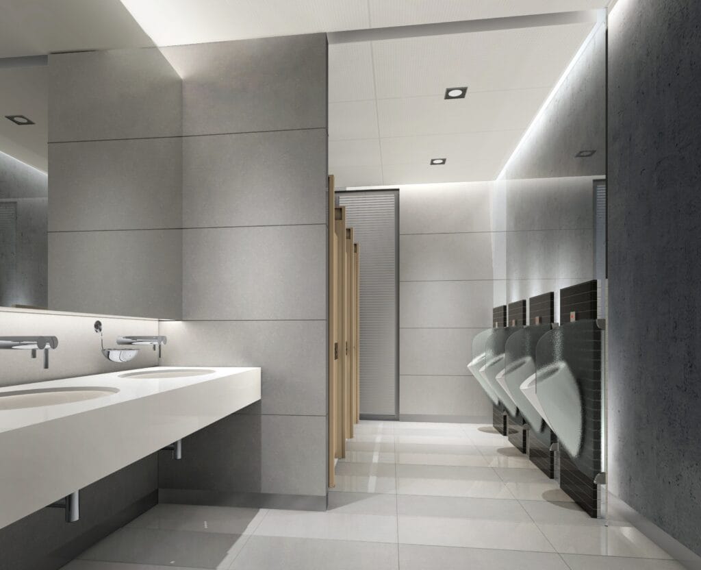 Modern bathroom with cove lighting above the mirrors and sinks with flanged recessed lights leading to the urinals and water closet